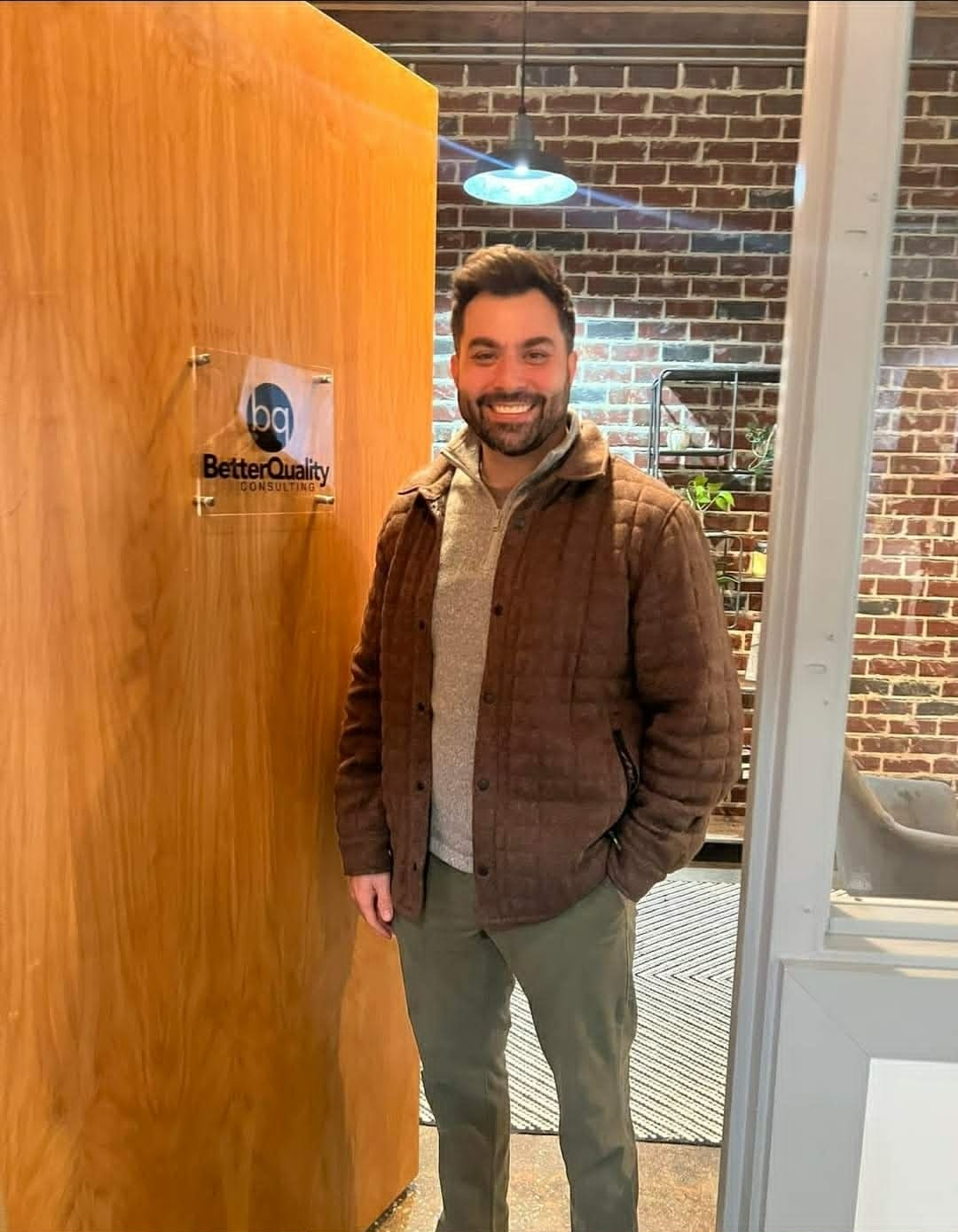 Joshua Breaux at the BetterQuality Consulting office entrance
